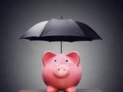 Photo of a piggybank with an umbrella.